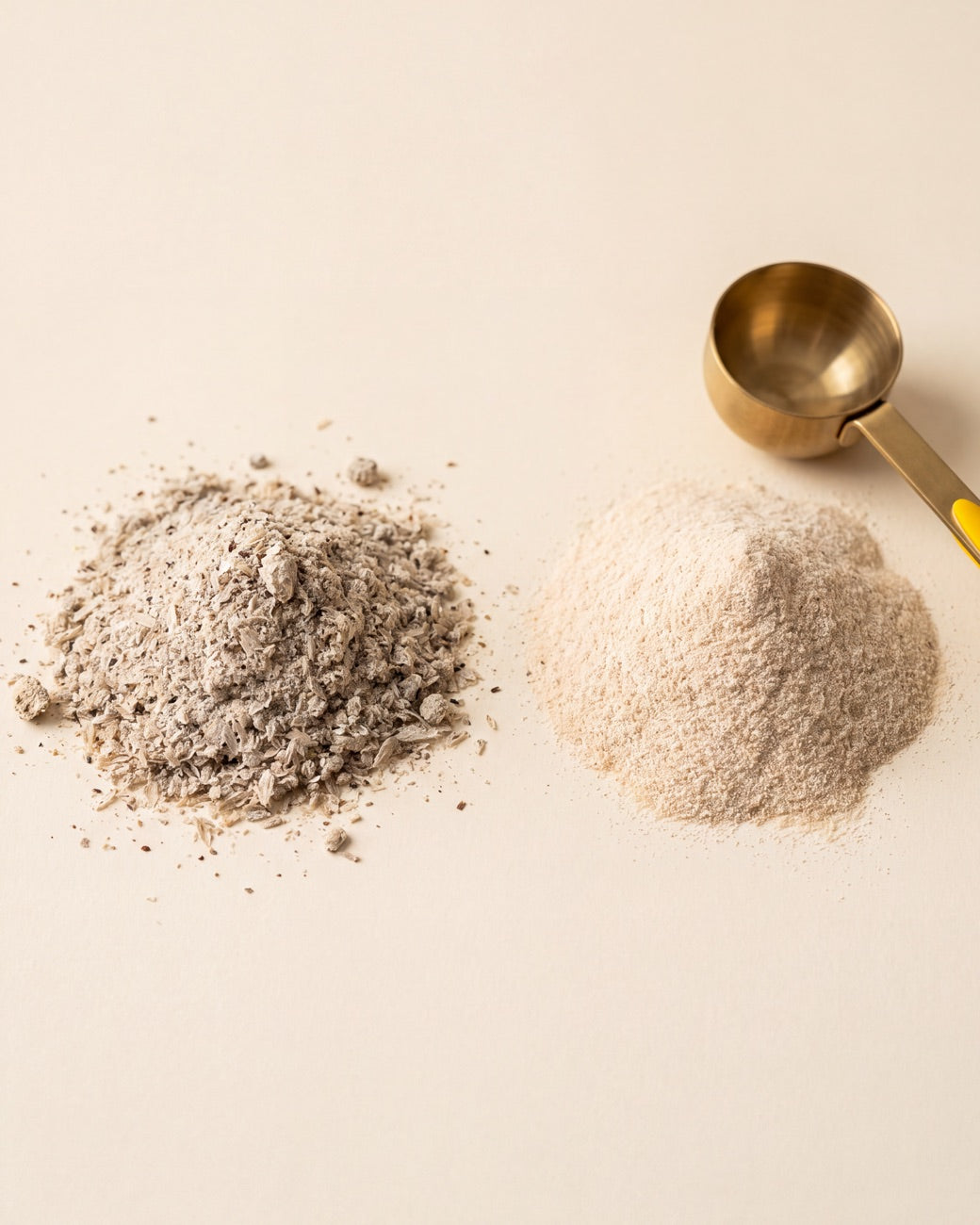 Two piles of psyllium powder side by side, a coarse gritty ordinary psyllium on the left and Pinch fine, evenly milled psyllium on the right beside a brass scoop